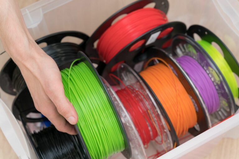 close-up male hand takes a spool of multicolored filament for 3d printer